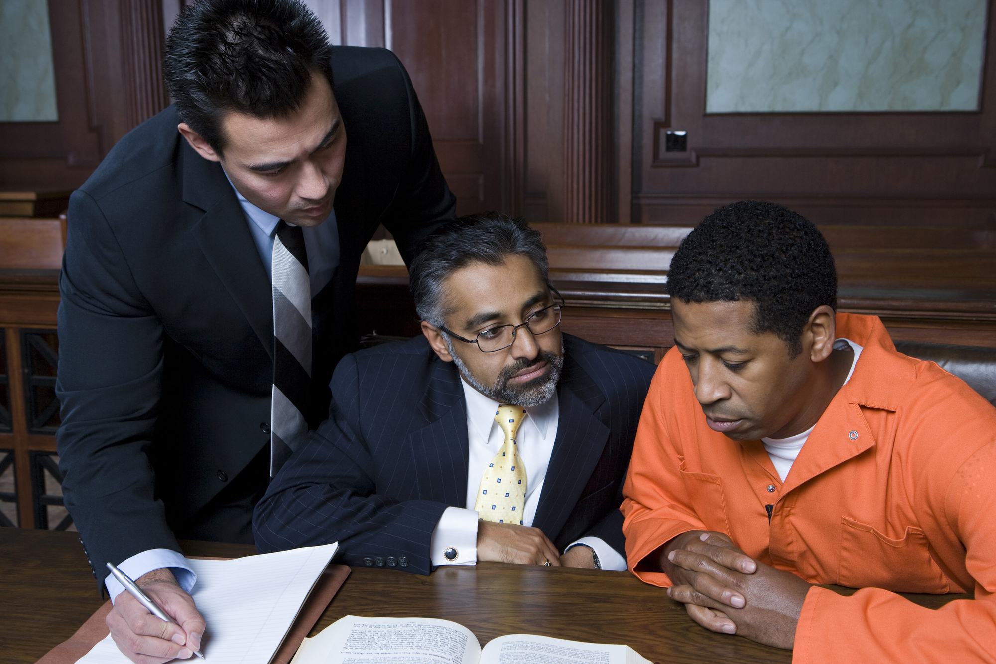 Two attorneys with client in courtroom