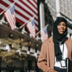 Woman in hijab standing in front of American flag